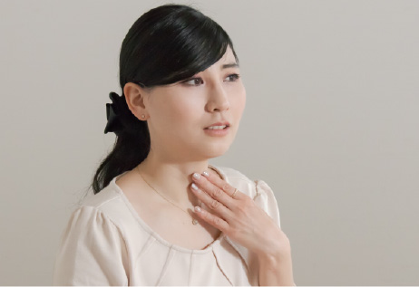 喉を押さえる女性